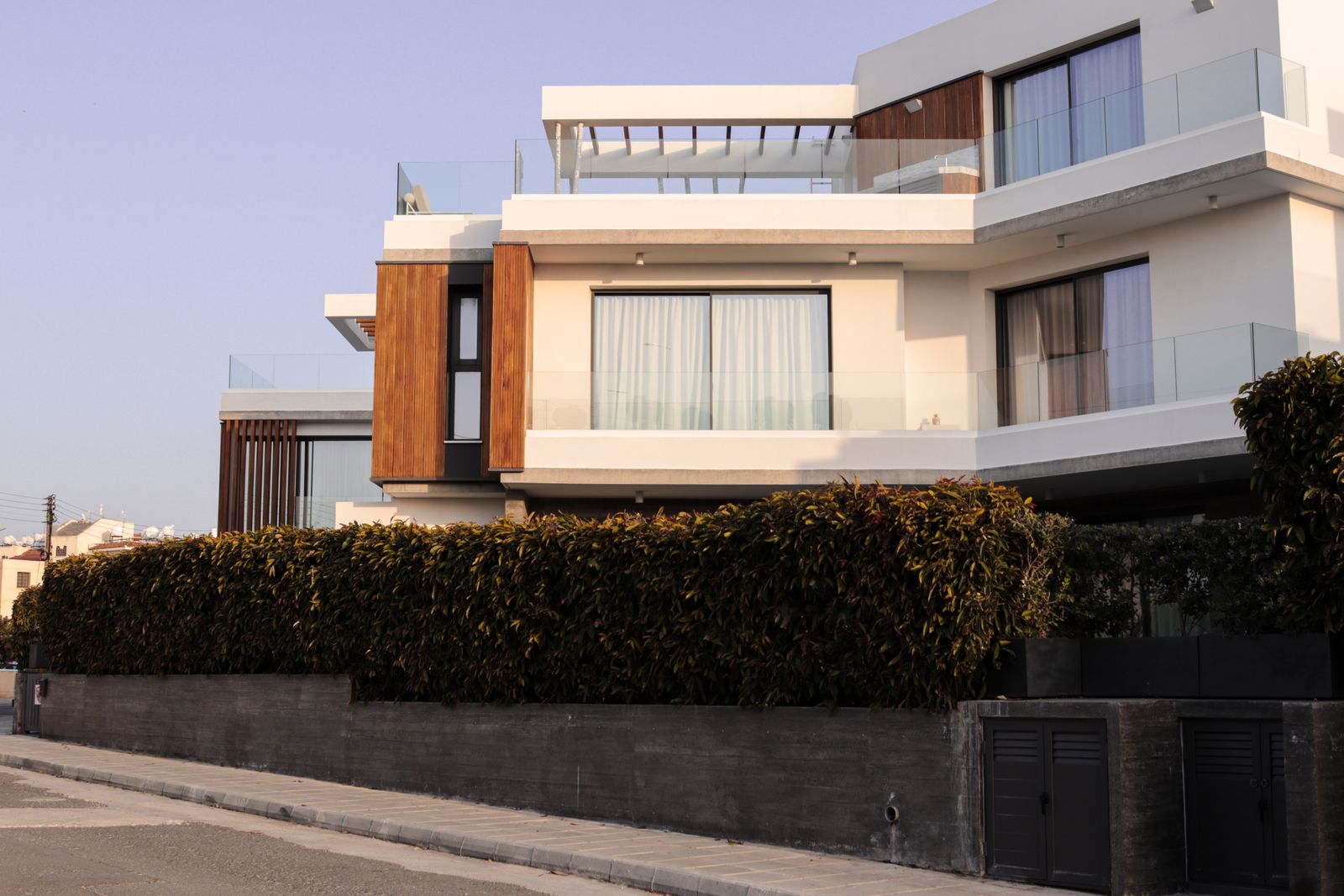 Modern residential villa exterior with wood cladding and glass balconies